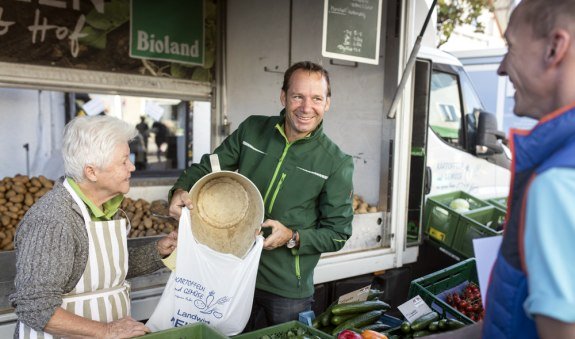 Herr Reiner schüttet Kartoffeln in eine Plastiktüte an seinem Marktstandt, © Florian Bachmeier